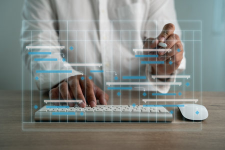 A computer monitor and laptop are placed on a desk with a calendar on the laptop.の写真素材