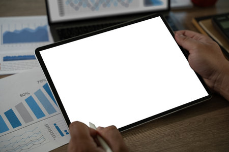 A businessman holds a mockup. iPad digital tablet with blank screen Mockup replaces your design mockup in the office.の写真素材