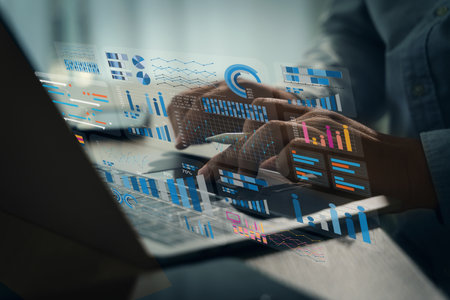 The business analyst used a laptop to analyze financial statistics, creating a digital dashboard for marketing performance reports.の写真素材