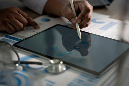 Insurance Healthcare Doctor analyzing medical report and medical on hospital backgroundの写真素材