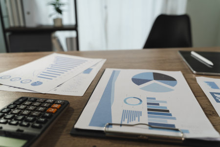A report file image shows desk with financial documents, charts, calculator, and notebook, indicating work or analysis environment with focus dataの写真素材
