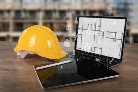 An engineer architect industry 4.0 digital blueprint of construction site displayed tablet with yellow safety helmet wooden table, symbolizing modernの写真素材