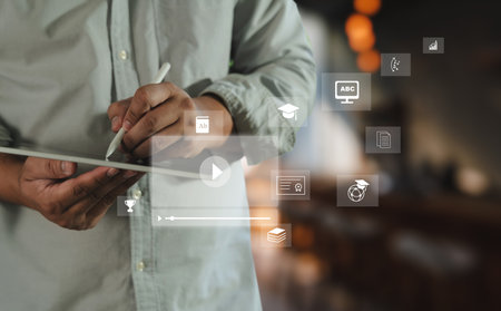 An educational video person using digital tablet with educational and learning icons floating around, symbolizing online education, digital learningの写真素材