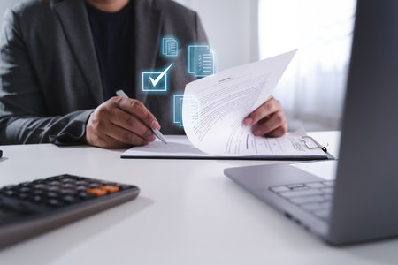 An approved the survey form checklist person reviewing documents desk with digital icons of checkmarks and files floating above, indicating digitalの写真素材
