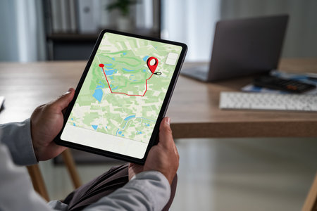 Man holding tablet with GPS navigation app showing map and route, modern digital technology for...