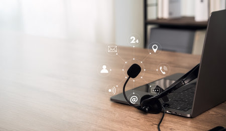 Customer service support concept with headset on laptop and technology 24 call help desk via phone email chat and call center communication.の写真素材
