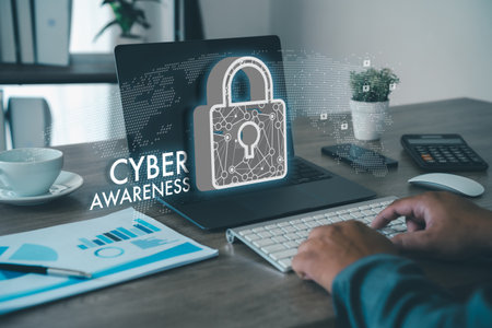 cyber security awareness Hands typing at an office desk with a laptop and a lock graphic, representing cybersecurity awareness and safe work practices.の写真素材