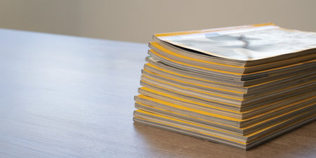 Magazines publication stack of printed magazines on table representing publishing, editorial work,...