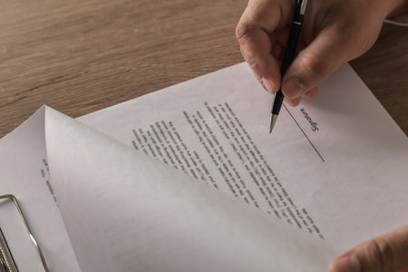 Cropped shot person pen signing a business contract , focus on signature form, secure legal...