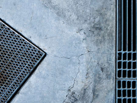 Steel grate of manhole cover duty drain on the concrete roadside.の写真素材