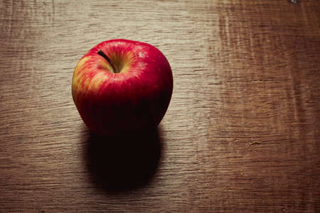 Ripe red apple on a wooden backgroundの写真素材