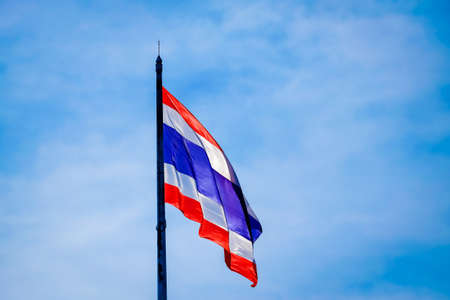 Image of waving Thai flag of Thailand with blue sky background.