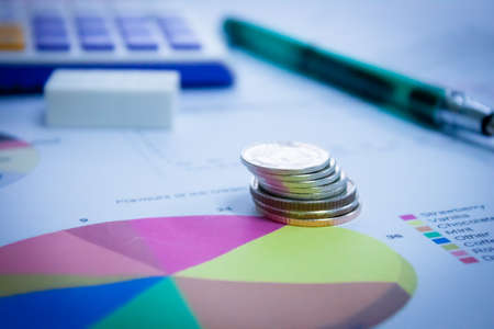 Coins from different countries, stacked in the financial schedule.の写真素材