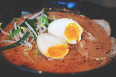 Ramen noodles in shoyu soup, Ramen Japanese food very popular in asia. Ramen noodles served with pork, seaweed and onsen eggs in shoyu soup or soy sauce soup on wood table.の写真素材