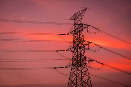 Sunset under the high-voltage tower in the backgroundの写真素材