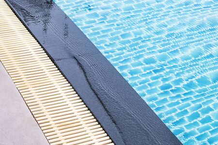 The edge of the pool is made of granite with a sieve for overflowing waterの写真素材