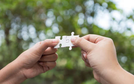 woman hands holding jigsaw puzzles, business matching conceptの写真素材