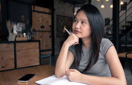 Asia woman thinking in coffee shop. Idea Conceptの写真素材
