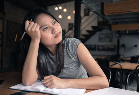 Boring woman thinking about project in coffee shopの写真素材