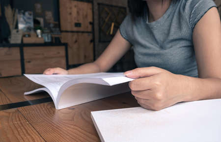 Woman reading a book in coffee shopの写真素材