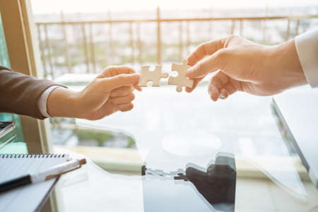 Close up two hands connect two jigsaw puzzle. business, success and strategy concept.の写真素材
