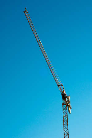 yellow hoisting crane isolate on blue sky. tower construction crane.の写真素材