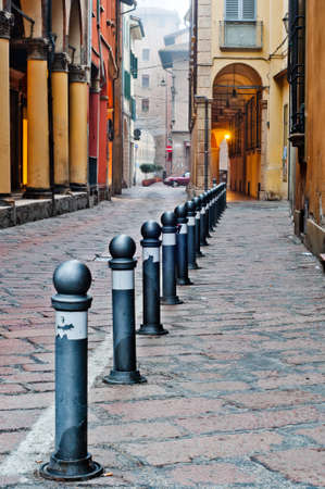 Old street view Bologna city, Italy. Cobble stone street with bollards. Renaissance buildings.の写真素材