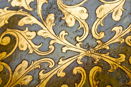 Fourish pattern. Gold leaf floral design on black background. Old, antique surface.の写真素材
