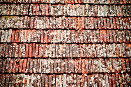Roof tiles texture. Detail of an old, weathered clay shingle roof texture. Damaged roof.の写真素材