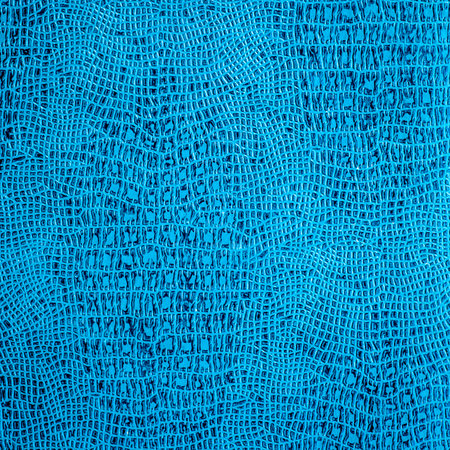 Close-up showcasing the intricate patterns and rich azure hue of faux blue leather. The texture, characterized by its woven design, exudes elegance and modernity, making it ideal for luxury interiors and fashionable accessoriesの写真素材