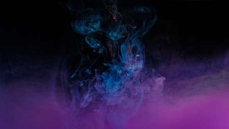 Color drop in water on black backgroundの写真素材