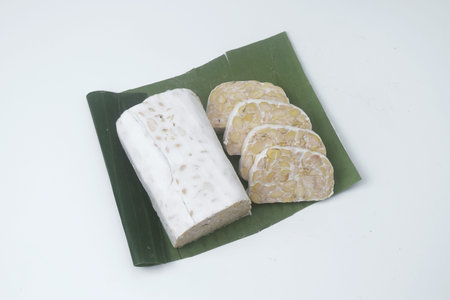 Close up photo of several pieces of raw food made from fermented soybeans and yeast and wrapped in banana leaves. in Indonesia this food is often called "Tempe". Isolated whiteの写真素材