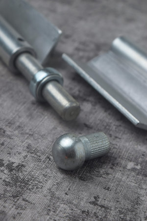 Closeup photo of an iron hinge with a cement background