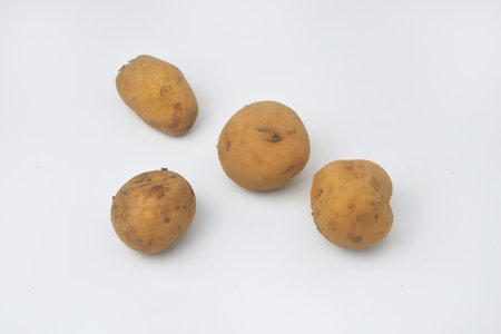 The photo looks from above of several raw potatoes on am isolated white backgroundの写真素材