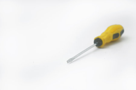 A yellow screwdriver often used by craftsmen is on an isolated white backgroundの写真素材