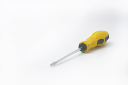 A yellow screwdriver often used by craftsmen is on an isolated white backgroundの写真素材
