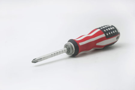A screwdriver patterned with the colors of the American flag is on an isolated white backgroundの写真素材