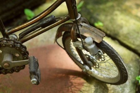 Close up photo of bicycle wheels from a toy bicycle craft with a beautiful green garden background