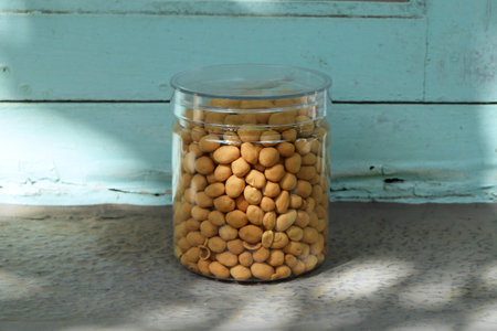 Dried beans in food storage or jar on light blue wooden window background