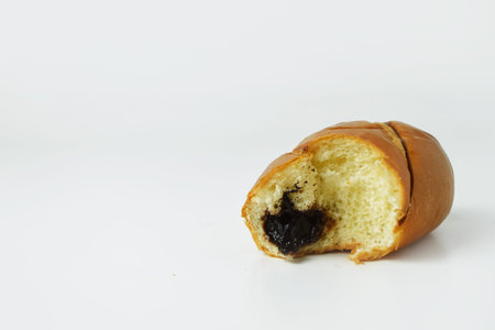 Chocolate bread that has been bitten on a white background