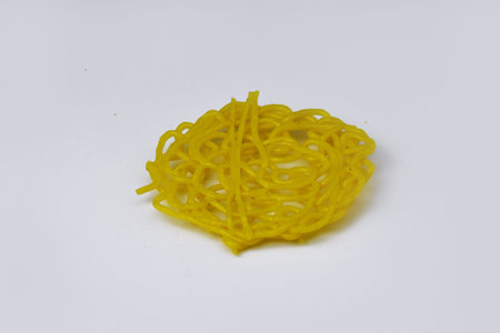 Yellow raw noodle on an isolated white background