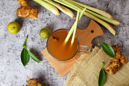 Top view photo of a healthy hot red ginger drink with a mixture of lemon and honey in a glass cup...