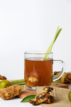 Closeup photo of Hot red ginger drink in glass on wooden coaster and isolated white background....
