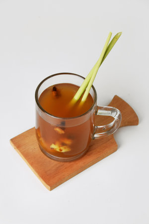 Hot red ginger drink in glass on wooden coaster and isolated white background. Healthy drinksの写真素材