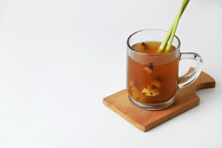 Red ginger drink in glass on wooden coaster and isolated white background. Healthy drinks can be used for treatmentの写真素材