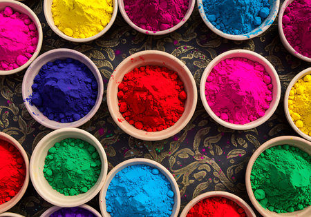 A high-angle close-up view of various vibrant Holi colors in small, shallow white bowls. Generative Aiの素材