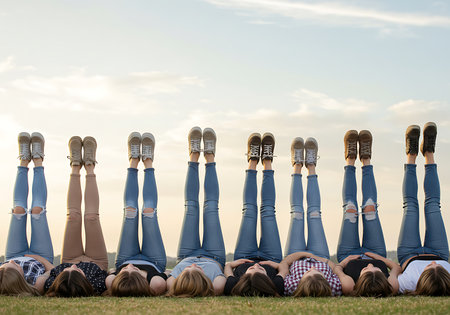 A group of teenage girls are lying on a grassy field, with their legs in the air. Generative Aiの素材