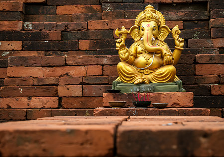 A golden statue of Ganesh, the Hindu god of beginnings, sits on a tiered brick platform, with incense burning nearby. Generative Aiの素材