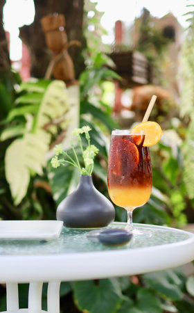 Iced coffee with orange juice in a glass on a table.の写真素材