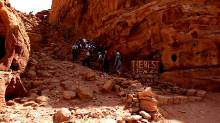 Petra, Jordan 19 04 2014: Tourists trekking up the mountain with best view sign in worldwonder in Petra in Jordanのeditorial素材